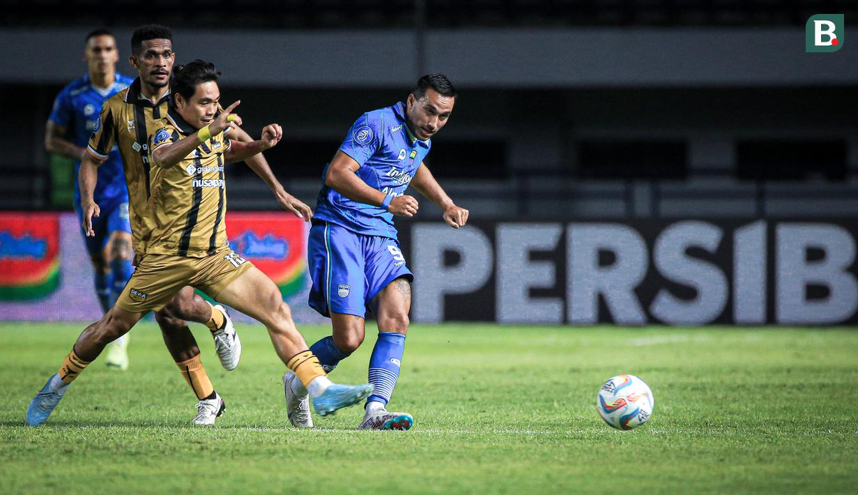 Pemain Persib Bandung, Ezra Walian (kanan), memberikan umpan dibayangi pemain Dewa United, Rangga Muslim, dalam pertandingan lanjutan pekan ketiga BRI Liga 1 2023/2024 yang berlangsung di Stadion Gelora Bandung Lautan Api, Jawa Barat, Jumat (14/7/2023). (Bola.com/Bagaskara Lazuardi)