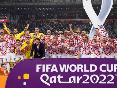 Sejumlah pemain dan pelatih Kroasia merayakan kegembiraan setelah pengalungan medali peringkat ketiga Piala Dunia 2022 di Khalifa International Stadium, Minggu (18/12/2022). (AP Photo/Hassan Ammar)