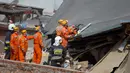 Petugas penyelamat mencari korban di reruntuhan sebuah apartemen tua yang ambruk di Swiebodzce, Polandia, Sabtu (8/4). Apartemen yang rubuh itu merupakan bangunan tua yang telah berdiri sebelum Perang Dunia II berlangsung. (Natalia DOBRYSZYCKA/AFP)