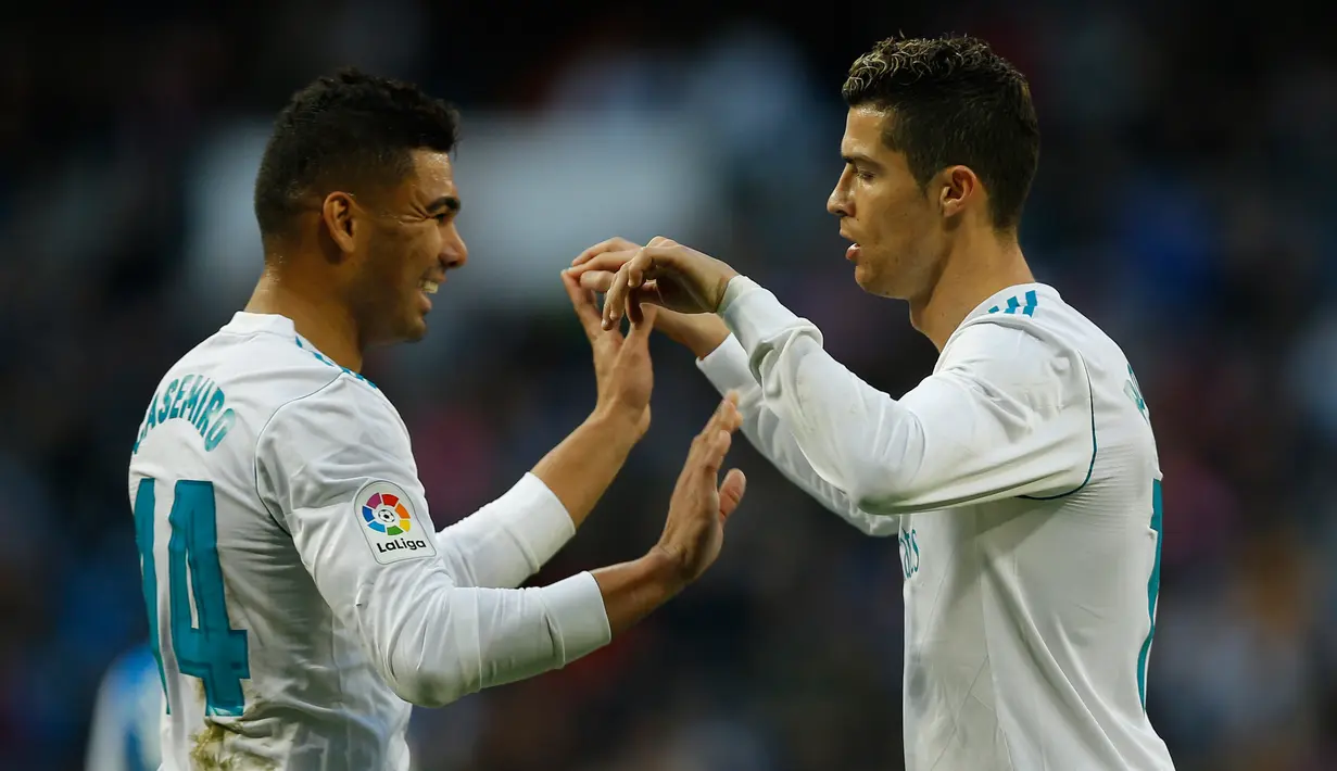 Pemain Real Madrid, Cristiano Ronaldo dan rekan setimnya, Casemiro merayakan gol ke gawang Deportivo La Coruna dalam lanjutan La Liga Spanyol di Santiago Bernabue, Senin (22/1). Real Madrid pesta kemenangan 7-1 atas Deportivo La Coruna (AP/Francisco Seco)