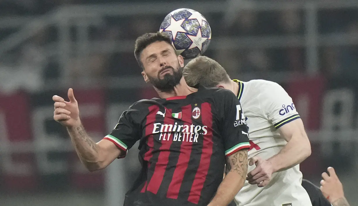 Penyerang AC Milan, Olivier Giroud berebut bola dengan pemain Tottenham Hotspur, Oliver Skipp selama pertandingan leg pertama babak 16 besar Liga Champions di stadion San Siro di Milan, Italia, Rabu (15/2/2023). AC Milan menang tipis atas Tottenham dengan skor 1-0. (AP Photo/Luca Bruno)