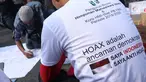 Salah satu pengurus PB HMI melihat warga yang menandatangani spanduk dukungan anti hoax di kawasan Bundaran Hotel Indonesia, Jakarta, Minggu (18/11). PB HMI mensosialisasikan Hoax sebagai ancaman demokrasi di Indonesia. (Liputan6.com/Helmi Fithriansyah)