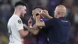 Pemain Fiorentina, Cristiano Biraghi, mendapat perawatan akibat menderita luka di bagian kepala setelah insiden pelemparan benda dari tribun suporter West Ham United pada laga final UEFA Europa Conference League di Stadion Eden Arena, Kamis (8/6/2023). Fiorentina takluk dengan skor 1-2. (AP Photo/Darko Bandic)