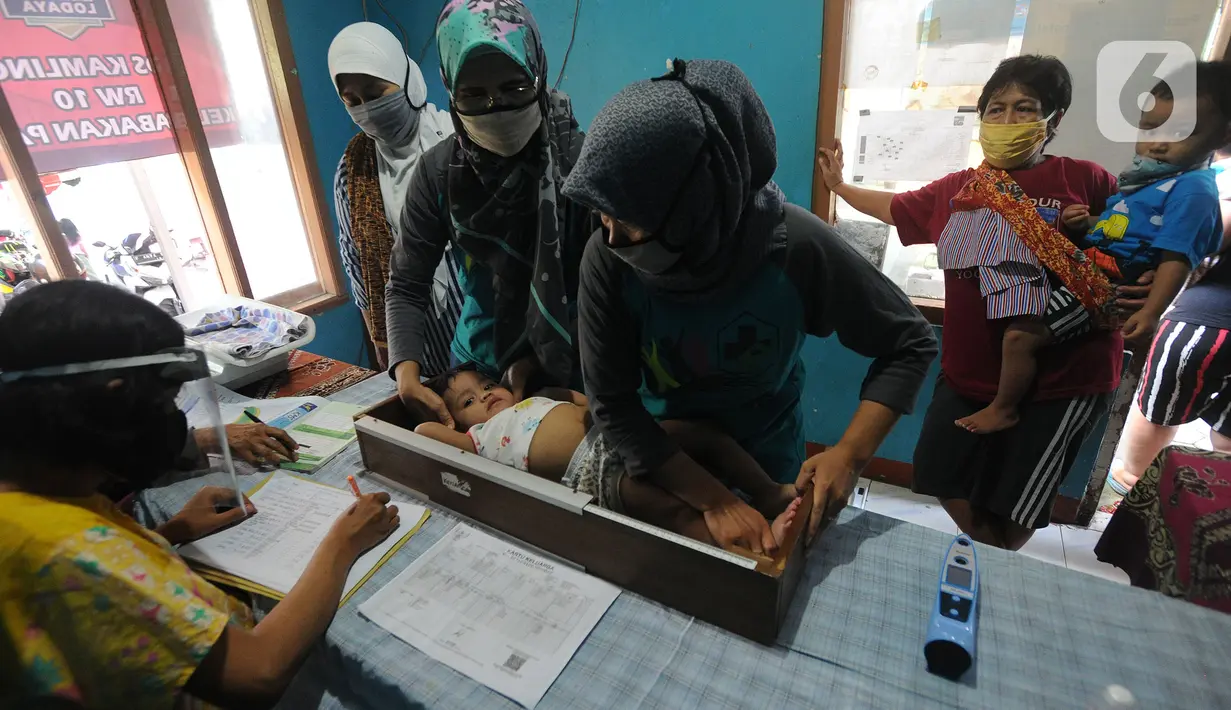 Petugas Posyandu mengukur tinggi badan balita sebelum pemberian vitamin A di Pos Ronda Kampung Kebon Jukut RW 10, Kelurahan Babakan Pasar, Kota Bogor, Kamis (6/8/2020). Kegiatan Posyandu untuk pertama kalinya selama pandemi corona ini bertepatan dengan pemberian vitamin A. (merdeka.com/Arie Basuki)