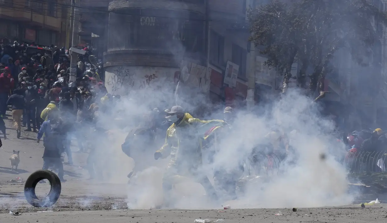 Petani koka anti-pemerintah melarikan diri dari gas air mata yang ditembakkan oleh polisi anti huru hara di dekat pasar koka di La Paz, Bolivia, Kamis (23/9/2021). Para petani koka anti-pemerintah  melakukan unjuk rasa terhadap perubahan pasar tradisional koka. (AP Photo/Juan Karita)