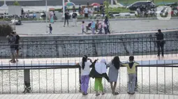 Warga saat menghabiskan waktu untuk menunggu berbuka puasa di Waduk Mookervart di Kalideres, Jakarta Barat, Minggu (9/5/2021). Waduk Mookervart tersebut dimanfaatkan oleh warga sekitar untuk ngabuburit atau menunggu waktu berbuka puasa tiba. (Liputan6.com/Angga Yuniar)