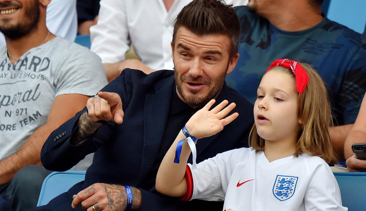 Legenda Timnas Inggris, David Beckham, bersama anak perempuannya, Harper Beckham, saat menyaksikan pertandingan antara Inggris melawan Norwegia pada laga Piala Dunia Wanita di Prancis, (27/6/2019). (Photo by LOIC VENANCE / AFP)