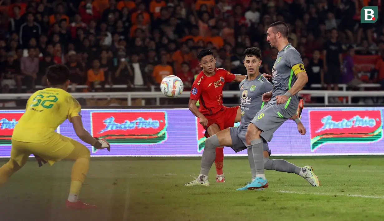 <p>Pemain Persija Jakarta, Ilham Rio Fahmi (tengah) melepaskan tendangan ke gawang Persebaya Surabaya pada laga lanjutan pekan ke-5 BRI Liga 1 2023/2024 antara Persija Jakarta melawan Persebaya Surabaya di Stadion Utama Gelora Bung Karno (SUGBK), Senayan, Jakarta, Minggu (30/7/2023). (Bola.com/Ikhwan Yanuar)</p>