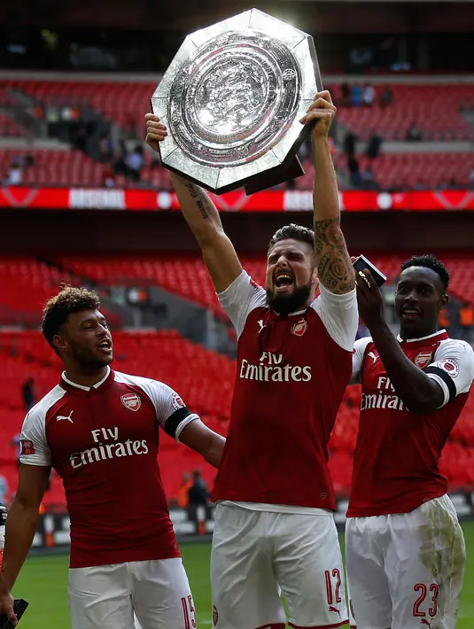 Pemain Arsenal Olivier Giroud mengangkat trofi Community Shield saat merayakan kemenangan dalam pertandingan FA Community Shield di Stadion Wembley di London, Inggris (6/8). (AP Photo / Frank Augstein)