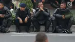 Personil kepolisian dari satuan Brimob beristirahat saat menjaga aksi unjuk rasa yang dilakukan Gerakan Nasional Kedaulatan Rakyat di depan Gedung Bawaslu, Jakarta, Selasa (21/5/2019). Ribuan aparat keamanan gabungan diterjunkan untuk mengamankan jalannya aksi. (Liputan6.com/Helmi Fithriansyah)