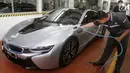 Seorang mekanik tengah mengisi daya BMW i8 saat pembukaan diler baru BMW di Tebet, Jakarta, Selasa (12/12). Diler ini dikhususkan untuk mobil listrik ramah lingkungan BMW i8. (Liputan6.com/Pool/BMW)