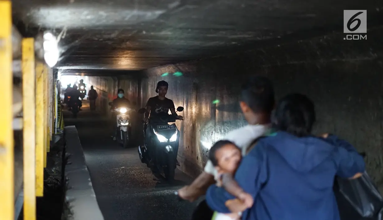 Pengendara motor melintasi terowongan di bawah Jalan Tol Jagorawi, kawasan Kampung Rambutan, Jakarta, Rabu (21/8/2019). Meskipun sempit dan gelap, namun terowongan itu menjadi akses alternatif pengguna jalan untuk menyeberangi Jalan Tol Jagorawi di kawasan tersebut. (Liputan6.com/Immanuel Antonius)