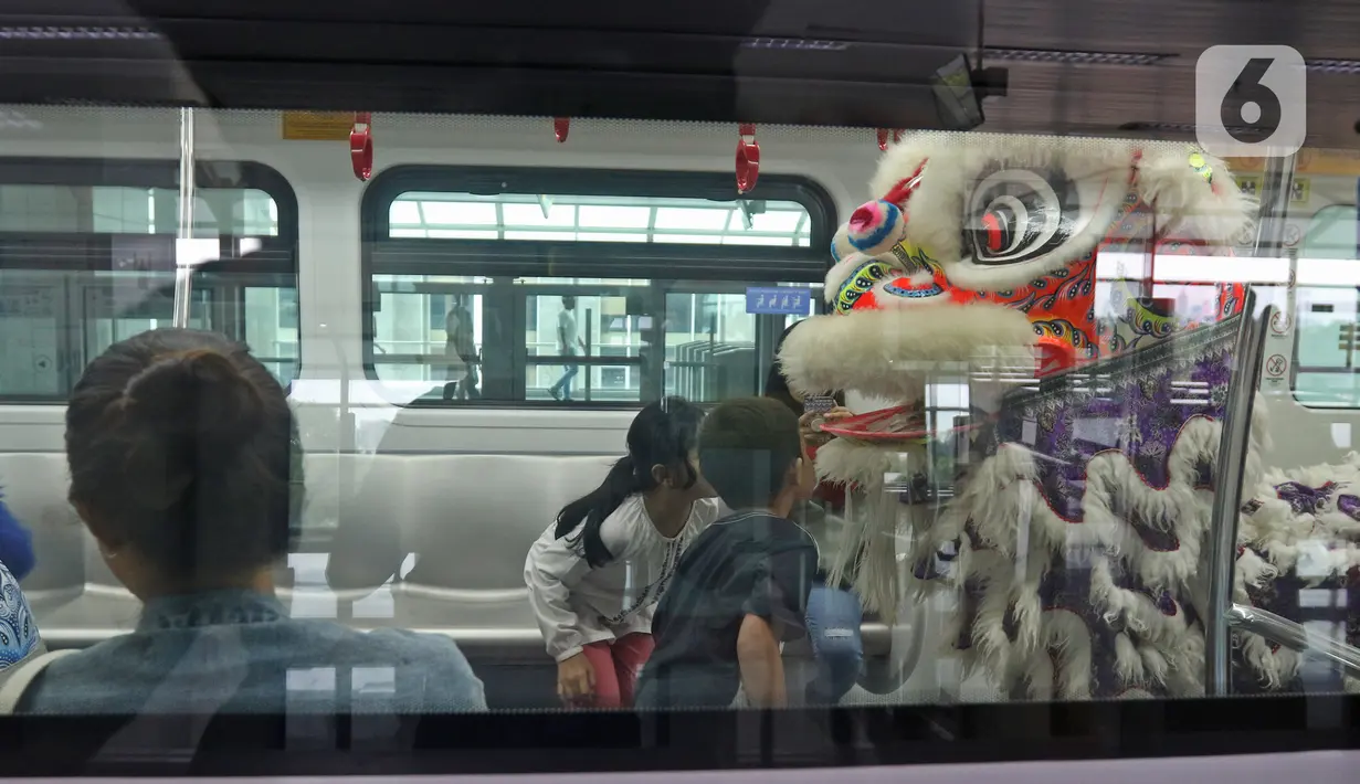 Atraksi Barongsai berkeliling untuk menghibur penumpang di Stasiun LRT Velodrome (25/1/2020). Pertunjukan tersebut dalam rangka perayaan tahun baru Imlek yang ke-2571. (Liputan6.com/Herman Zakharia)