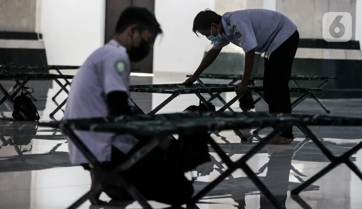 Petugas mengecek kondisi velbed di ruangan yang akan dijadikan tempat isolasi pasien COVID-19 di Aula Masjid KH Hasyim Asyari atau Masjid Raya Jakarta, Daan Mogot, Jumat (25/6/2021). Sebanyak 100 tempat tidur disiapkan bagi pasien OTG untuk dijadikan tempat isolasi mandiri (Liputan6.com/Johan Tallo