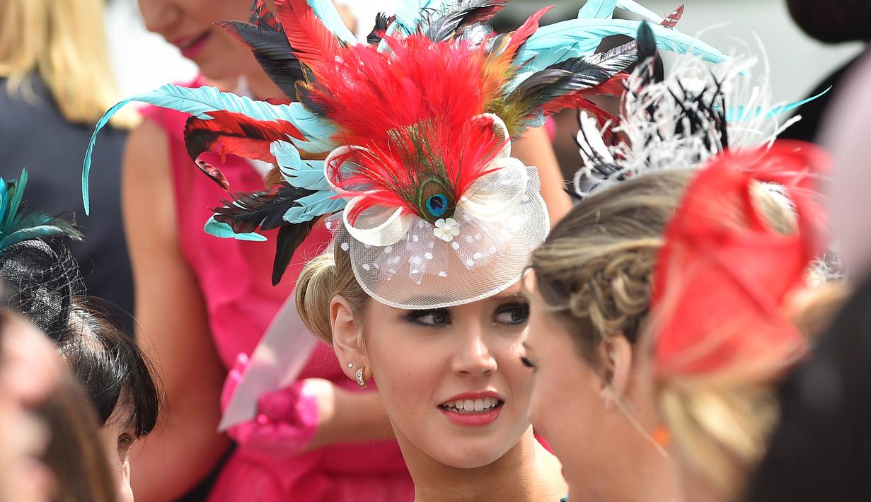 Wanita memakai hiasan kepala dari berbagai macam bulu saat menghadiri balap kuda Melbourne di arena pacuan kuda Flemington Racecourse, Australia (1/11). Flemington merupakan arena pacuan kuda sekaligus tempat hiburan kelas dunia. (AFP/Paul Crock)