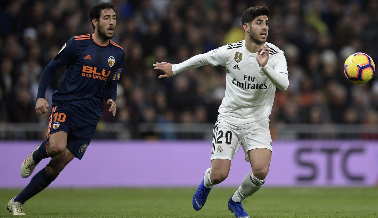 Gelandang Real Madrid, Marco Asensio, berebut bola dengan gelandang Valencia, Daniel Parejo, pada laga La Liga di Stadion Santiago Bernabeu, Madrid, Sabtu (1/12). Madrid menang 2-0 atas Valencia. (AFP/Oscar Del Pozo)