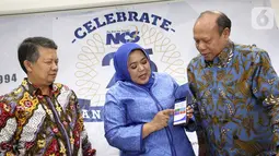 Dirut PT Nusantara Card Semesta (NCS) Reni S. Siregar (tengah) menunjukkan aplikasi NCS di Jakarta, Jumat (6/12/2019). NCS melakukan berbagai inovasi untuk menunjang kebutuhan bisnis proses dan service yang dari mulai pick up, delivery, invoicing hingga reporting melalui iDss. (Liputan6.com)