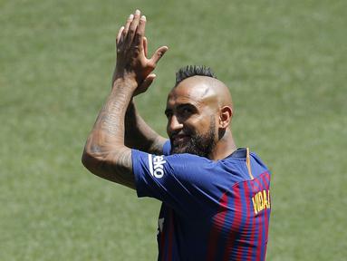 Pemain baru Barcelona, Arturo Vidal, menyapa fans saat perkenalan di Stadion Camp Nou, Senin, (7/8/2018). Barcelona merogoh kocek sebesar 19 juta euro untuk mengamankan jasa pria berkebangsaan Cile itu. (AP/Manu Fernandez)