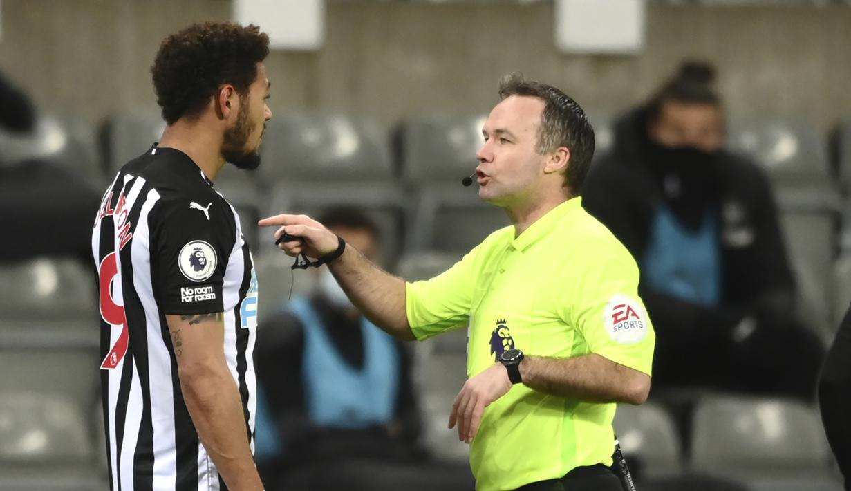 Striker Newcastle United, Joelinton (kiri) beradu argumen dengan wasit Paul Tierney dalam laga lanjutan Liga Inggris 2020/2021 pekan ke-28 di St. James' Park, Jumat (12/3/2021). Newcastle United bermain imbang 1-1 dengan Aston Villa. (AP/Stu Forster/Pool)