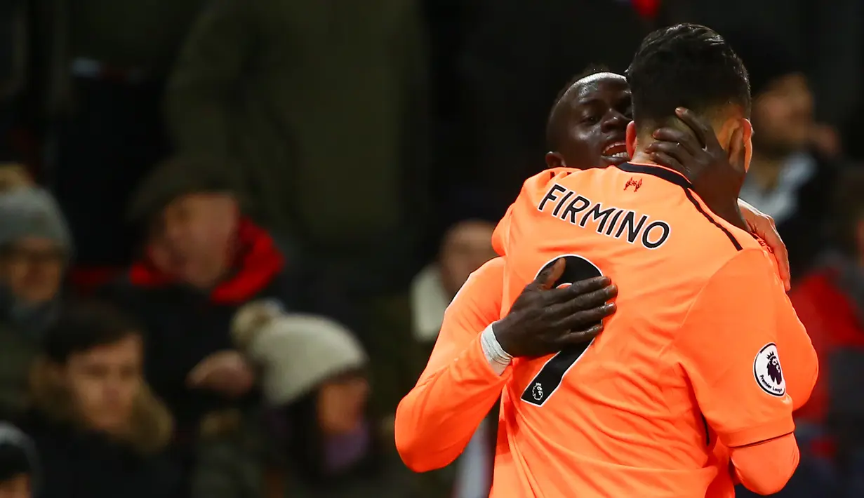 Gelandang Liverpool, Sadio Mane bersama rekan setimnya, Roberto Firmino merayakan gol ke gawang Stoke City pada pekan ke-14 Premier League di Bet365 Stadium, Kamis (30/11). Liverpool berhasil membantai Stoke City dengan skor 3-0. (Geoff CADDICK/AFP)
