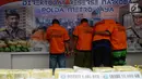 Sejumlah tersangka kasus narkoba menutupi wajah mereka saat gelar perkara di Polda Metro Jaya, Jakarta, Jumat (1/3). Subdit II Resnarkoba menyita sabu seberat 10 Kg dan 1.105 butir ekstasi jenis diamond. (Merdeka.com/ImamBuhori)