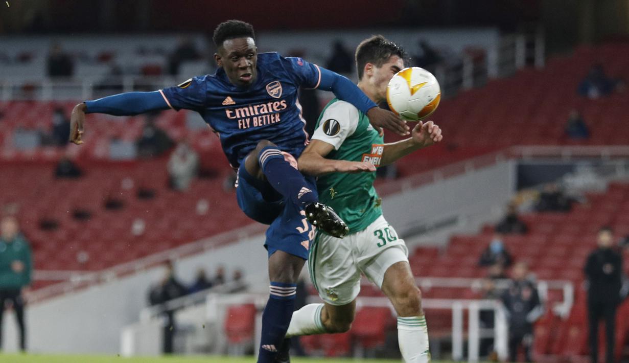 Striker Arsenal, Folarin Balogun (kiri), melepaskan tendangan dibawah tekanan bek Rapid Wien, Leo Greiml, dalam laga lanjutan Liga Europa 2020/21 Grup B di Emirates Stadium, Kamis (3/12/2020) waktu setempat. Arsenal mengalahkan Rapid Wien 4-1. (AFP/Adrian Dennis)