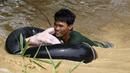 Seorang pria menyelamatkan hewan peliharaannya yang terkena banjir pasca bencana angin topan Koppu di Nueva Ecija,  Filipina, Senin (19/10/2015). Badai menyebabkan ratusan rumah hancur  dan 10.000 orang terpaksa mengungsi. (REUTERS/Erik De Castro)