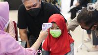 Anak sedang ukur suhu tubuh sebelum menjalani vaksinasi di Lippo Mall Kemang, Jakarta, Minggu (16/01/2022). Enam Lippo Malls di wilayah Jabodetabek dibawah Lippo Malls Indonesia Retail Trust (LMIRT) serentak menyediakan 1000 dosis vaksin bagi anak umur 6-11 tahun. (Liputan6.com/Fery Pradolo)