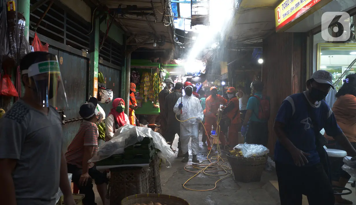 Petugas Palang Merah Indonesia (PMI) melakukan spraying pasar Karang Anyar dengan cairan disinfektan, Jakarta Pusat, Rabu (24/6/2020). Penyemprotan cairan disinfektan yang dilakukan tesebut untuk memutus penyebaran virus corona (COVID-19) pada PSBB Transisi new normal. (merdeka.com/Imam Buhori)