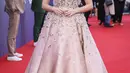 Aimee Lou Wood berpose di depan fotografer saat tiba untuk pemutaran perdana film 'Living' selama Festival Film London 2022 di London, Minggu, 9 Oktober 2022. Bintang Sex Education berusia 27 tahun itu tampil glamor dalam balutan gaun rose gold dengan detail permata. (Photo by Vianney Le Caer/Invision/AP)