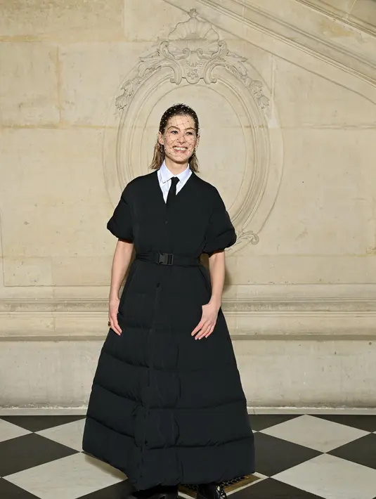 Tak ketinggalan, aktris Rosamund Pike mengenakan mantel taffeta teknis berlapis Dior Pre Fall 2022 hitam dengan kemeja katun putih dan dasi hitam. Bintang “I Care a Lot” ini juga mengenakan kerudung hitam Dior dan sepatu bot Dior. (Dior)
