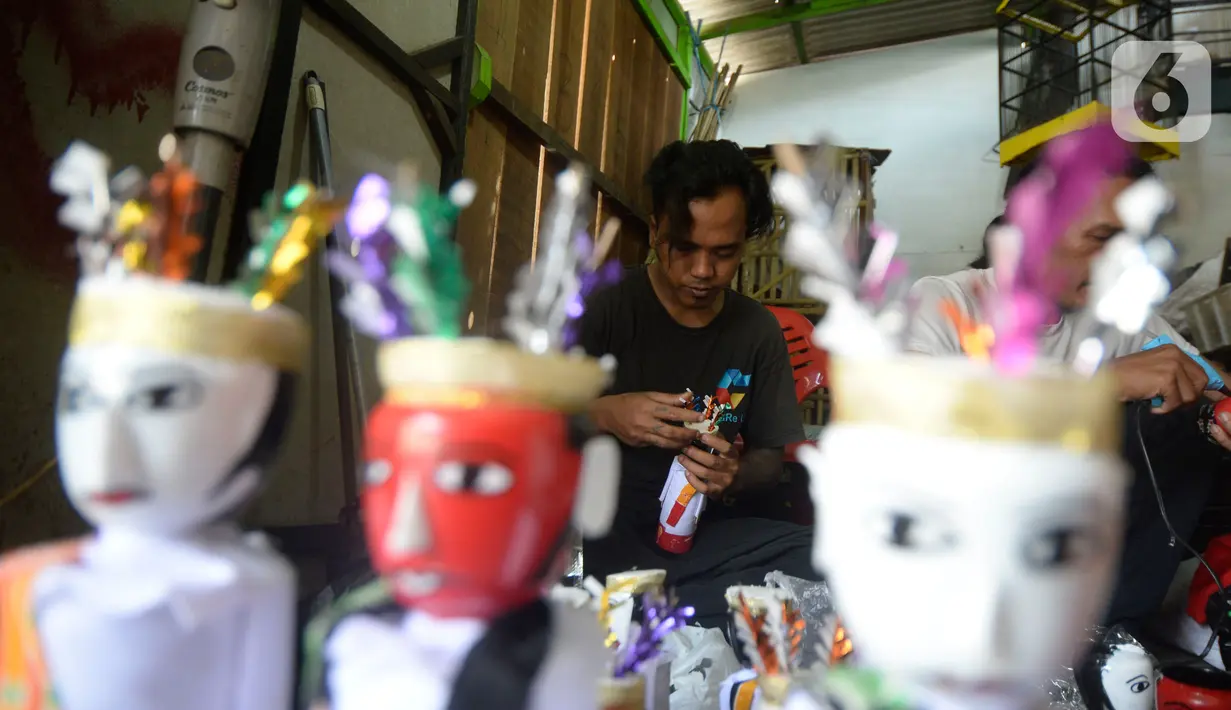Pengrajin sedang menyelesaikan ondel-ondel hiasan yang terbuat dari limbah plastik botol di Kampung Sawah Lama, Ciputat, Tangerang Selatan, banten, Jumat (4/9/2020). Dalam satu hari perajin bisa menyelesaikan 30 biji kerajinan ondel-ondel budaya khas Betawi. (merdeka.com/Dwi Narwoko)