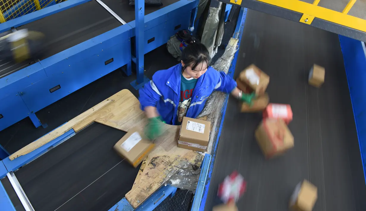 Seorang pekerja ZTO Express menyiapkan paket untuk dipindai dan didistribusikan di kawasan logistik tingkat provinsi di Wilayah Longli, Provinsi Guizhou, China pada 10 November 2020. Perusahaan-perusahaan logistik bersiap menyambut musim belanja "11.11" di China. (Xinhua/Dai Tianfang)