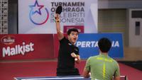 Selebritas Aldi Taher berusaha mengembalikan bola ke arah Rizky Billar saat laga tenis meja Turnamen Olahraga Selebriti Indonesia (TOSI) di GOR UNJ, Jakarta, Minggu (16/07/2023). Aldi Taher kalah tiga set langsung dari Rizky Billar dengan skor 12-21, 15-21, 11-21. (Bola.com/Bagaskara Lazuardi)