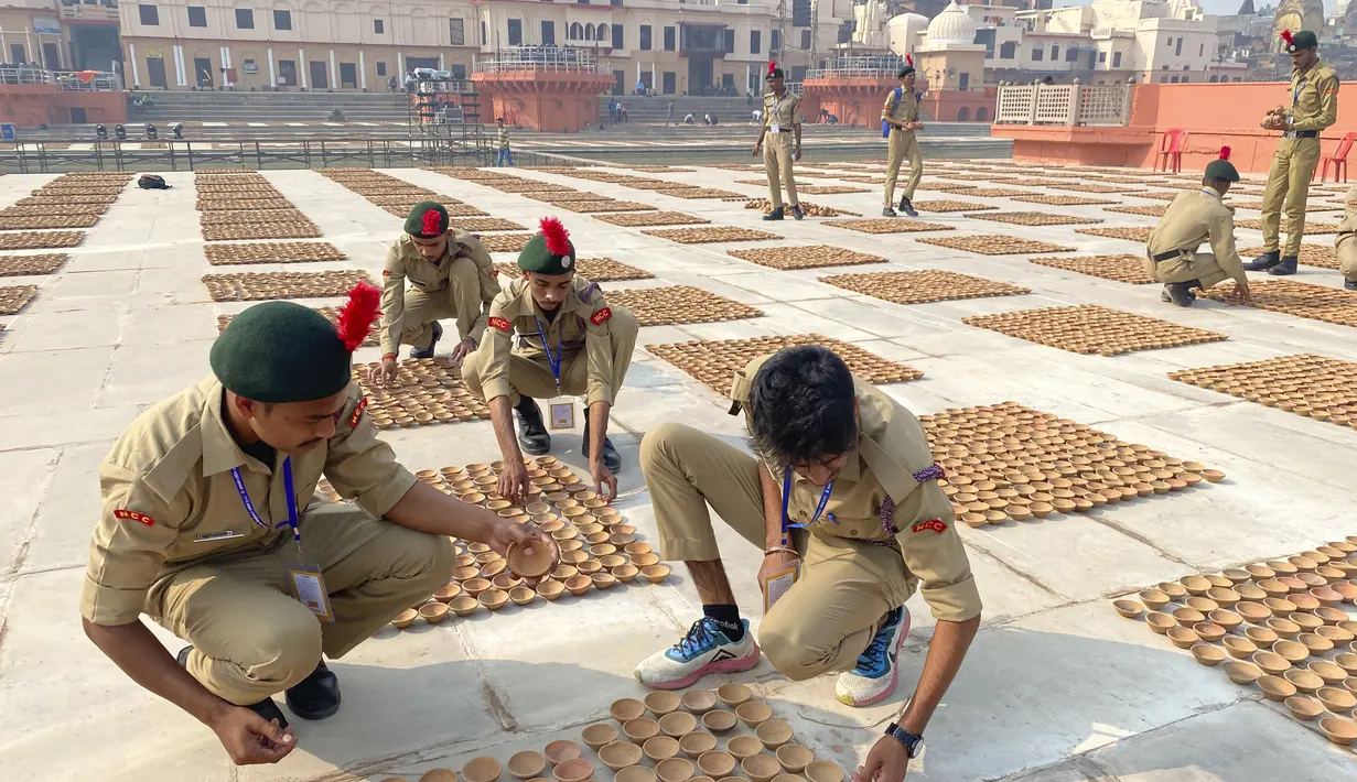 Taruna Korps Kadet Nasional menata lampu tanah di tepi sungai Saryu di Ayodhya, India, Selasa (2/11/2021). Ratusan ribu lampu akan dinyalakan pada perayaan Deepotsav pada malam Diwali. (AP Photo/Rajesh Kumar Singh)