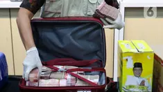 Petugas Komisi Pemberantasan Korupsi (KPK) mengeluarkan uang sitaan hasil Operasi Tangkap Tangan (OTT) di lingkungan Provinsi Kalimantan Selatan di gedung Merah Putih, Jakarta, Selasa (8/10/2024). (Liputan6.com/Herman Zakharia)