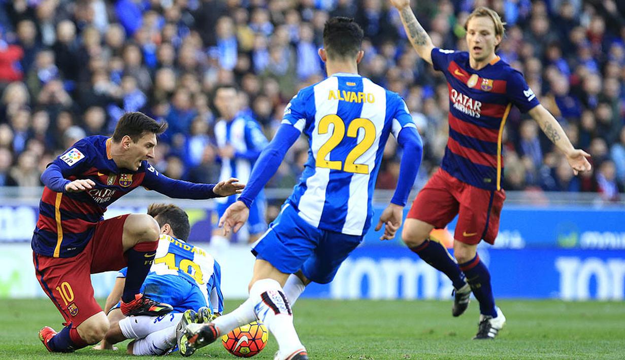 Pemain Barcelona berkebangsaan Argentina, Lionel Messi, terjatuh akibat tekel pemain Espanyol pada laga La Liga Spanyol. Beda poin Barca dan Madrid kini menjadi tiga angka. (AFP/Pau Barrena)
