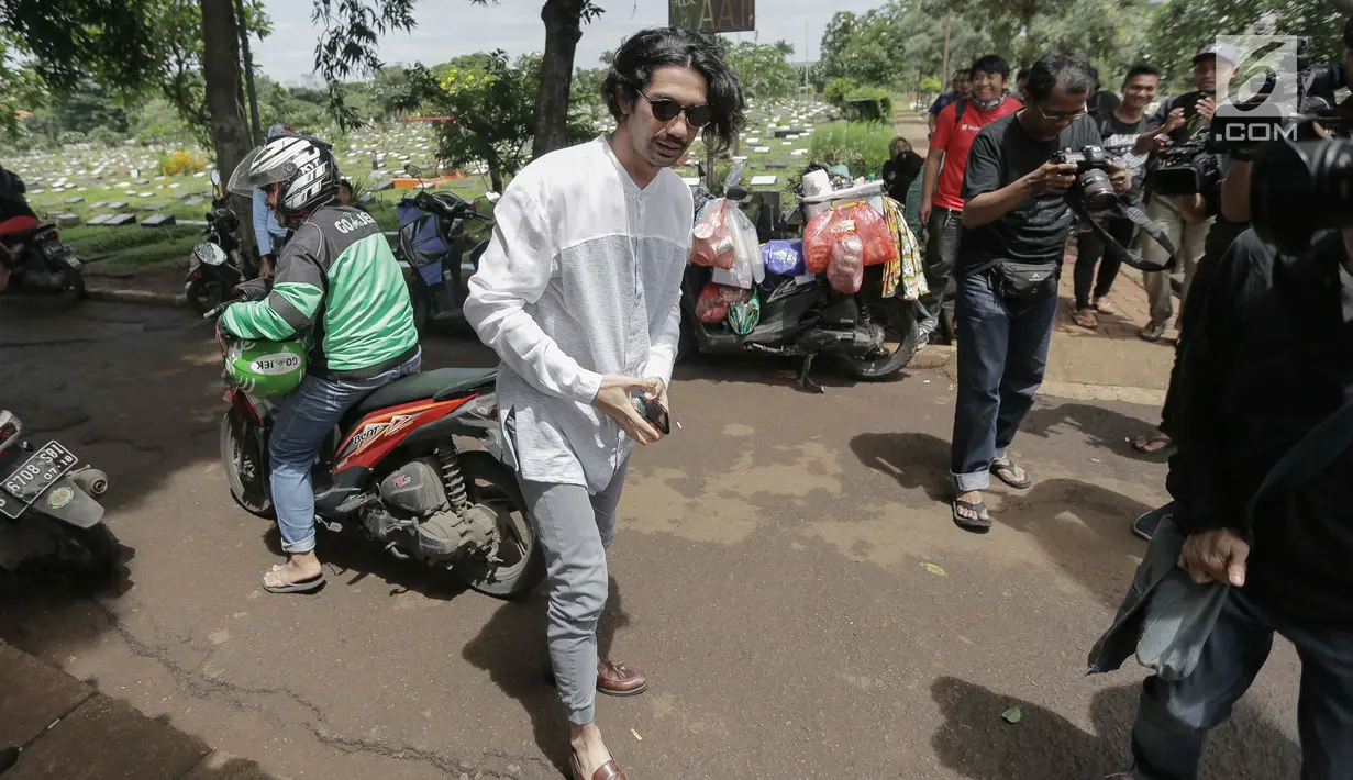 Aktor Reza Rahadian selaku pemeran Benyamin Sueb dalam film Benyamin: Biang Kerok  ziarah ke makam Benyamin Sueb di Karet Bivak, Jakarta, Jumat (26/1). (Liputan6.com/Faizal Fanani)