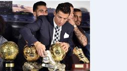 Bintang Real Madrid Cristiano Ronaldo membetulkan posisi sepatu emasnya saat acara seremoni penghaargaan atas pencapain sebagai Top Skor sepanjang masa El Real di Stdion Santiago Bernabeu, Madrid, Jumat (2/10/2015).  AFP Photo / Gerard Julien