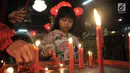 Seorang anak menyalakan lilin saat berdoa di Klenteng Boen Tek Bio, Pasar Lama, Tangerang, Kamis (31/1).  Klenteng yang dibangun tahun 1684 ini merupakan rumah ibadah yang ramai dikunjungi oleh umat Tionghoa. (Merdeka.com/Iqbal S. Nugroho)