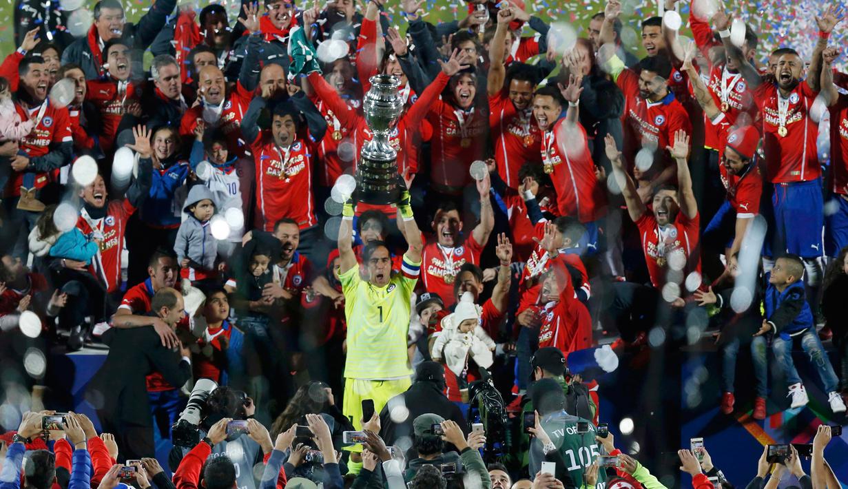 Kiper Chili, Claudio Bravo mengangkat trofi usai mengalahkan Argentina saat Final Copa America 2015  di Stadion Nasional, Santiago, Chili, (4/7/2015). Chili menang lewat adu penalti atas Argentina dengan skor 4-1. (REUTERS/Ueslei Marcelino)