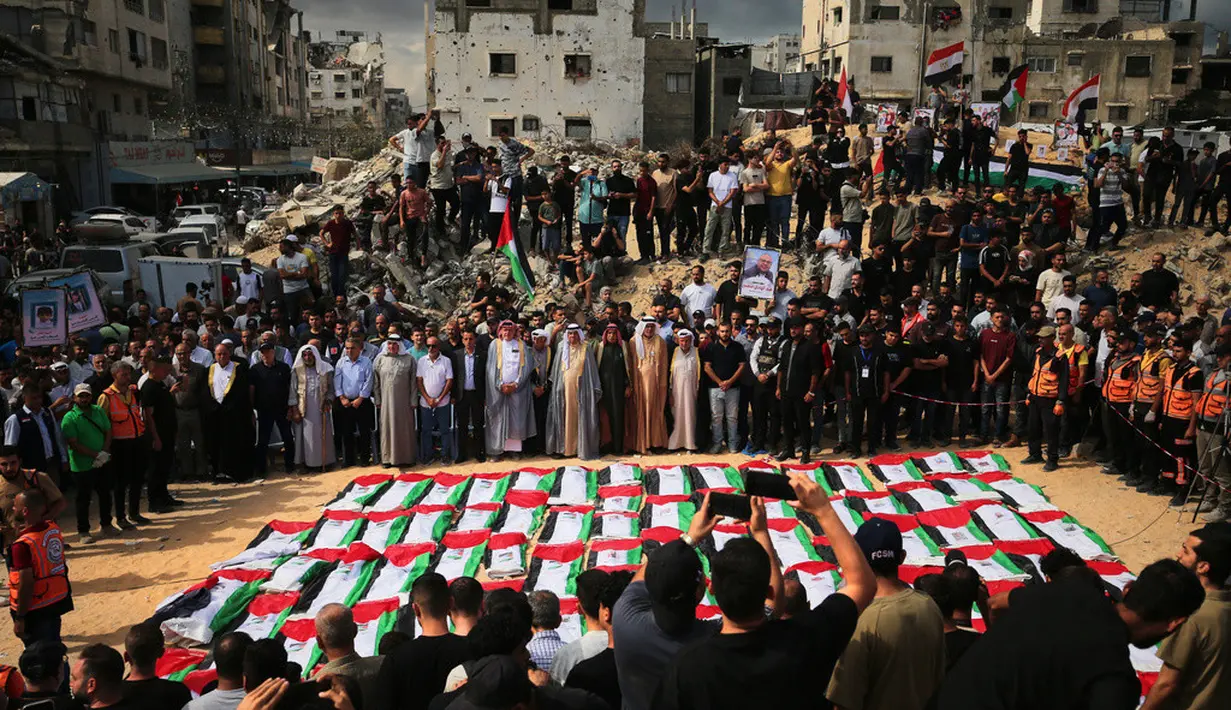 Warga Palestina berkumpul di sekitar jenazah warga Palestina yang tewas dalam serangan Israel selama perang dengan Hamas setelah ditemukan dari bawah reruntuhan bangunan. Jenazah yang dibungkus bendera Palestina tersebut dibawa dalam prosesi pemakaman di Kota Gaza, Kamis (1/10/2026). Keluarga dan warga setempat berkumpul untuk memberikan penghormatan terakhir kepada para korban dalam suasana duka. (AP Photo/Yousef Al Zanoun)
