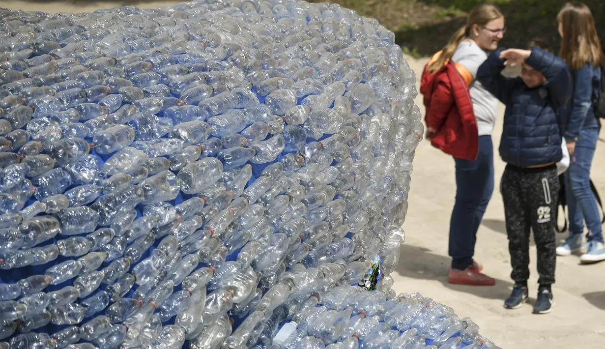 Pengunjung melihat-lihat patung paus raksasa, Plasticus yang dipajang di depan Auditorium Parco della Musica, Roma, Italia, Senin (16/4). Plasticus akan dipamerkan selama Festival Sains Geografi Nasional di Roma. (Andreas SOLARO/AFP)