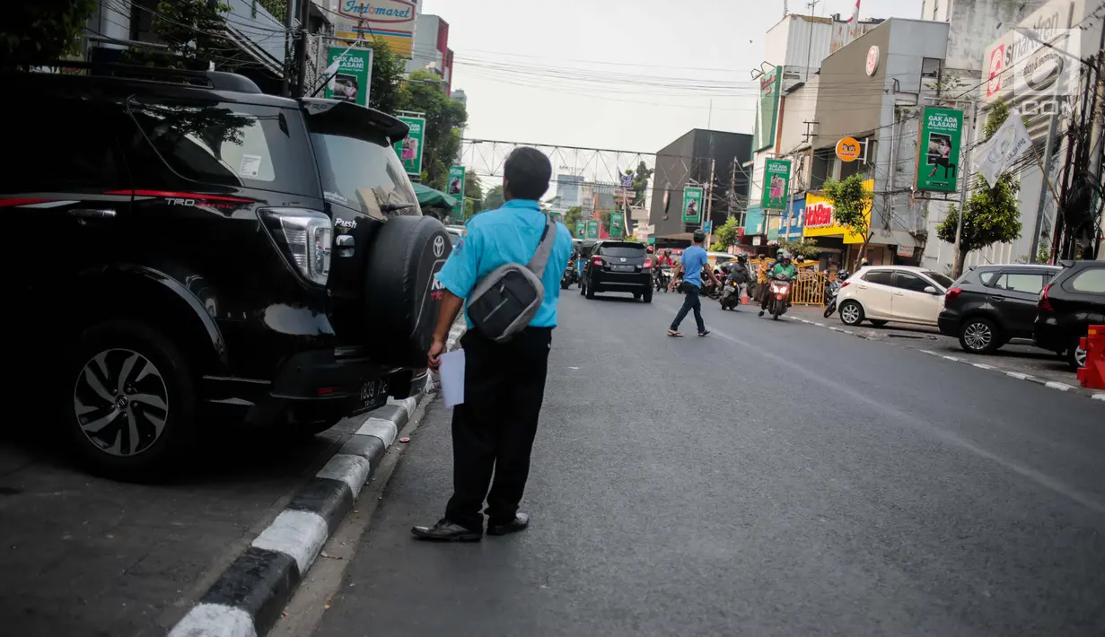 Petugas mengatur parkir kendaraan di Jalan H. Agus Salim, Menteng, Jakarta, Kamis (4/10). Pada 8-22 Oktober 2018 mendatang Jalan KH Wahid Hasyim dan Jalan H Agus Salim akan diberlakukan uji coba Sistem Satu Arah (SSA). (Liputan6.com/Faizal Fanani)