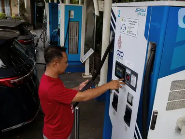 Pemilik kendaraan melakukan pengisian daya kendaraan listrik di SKPLU, Jakarta, Minggu (5/1/2025). (Liputan6.com/Angga Yuniar)