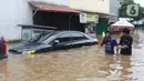 Warga melintasi banjir di perumahan Ciledug Indah, Tangerang, Rabu (1/1/2020). Banjir setinggi dada orang dewasa terjadi akibat meluapnya kali angke. (Liputan6.com/Angga Yuniar)