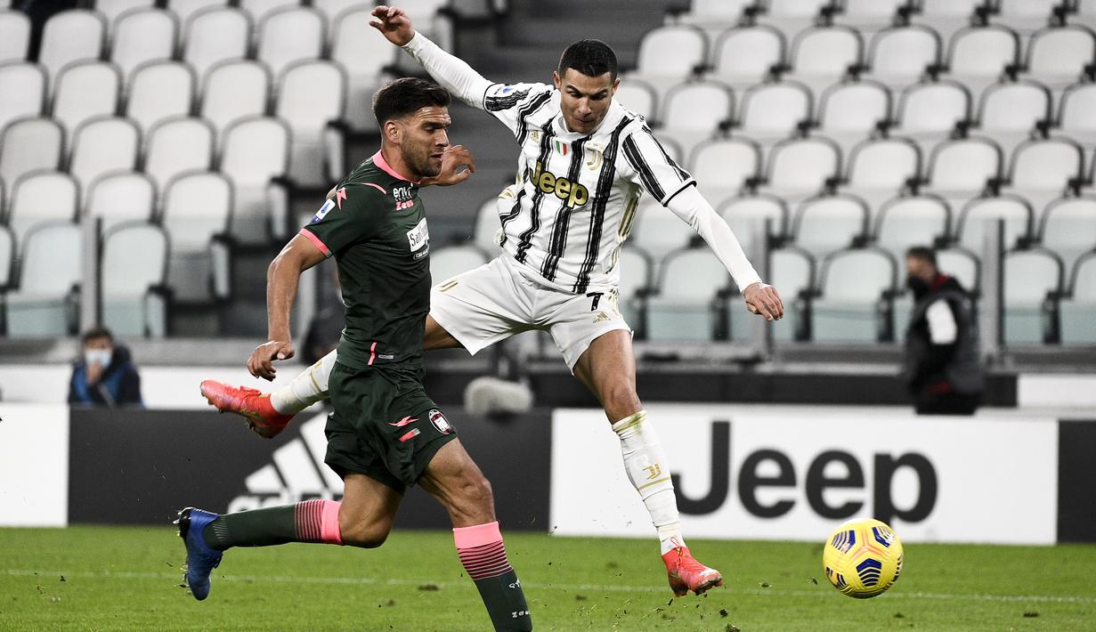 Penyerang Juventus, Cristiano Ronaldo berebut bola dengan bek Crotone, Lisandro Magallan dalam lanjutan Liga Italia di Allianz Stadium, Selasa dinihari WIB (23/2/2021). Ronaldo menyumbang dua gol pada laga ini, sedangkan satu gol lagi disumbang Weston McKennie. (Marco Alpozzi/LaPresse via AP)