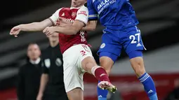 Bek Leicester City, Timothy Castagne berebut bola udara dengan bek Arsenal, Kieran Tierney  pada pertandingan lanjutan Liga Inggris di Stadion Emirates di London, Inggris, Minggu (25/10/2020). Leicester City menang 1-0 atas Arsenal. (Will Oliver/Pool via AP)