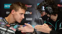 Pembalap Petronas Yamaha, Fabio Quartararo, berbincang dengan teknisinya usai latihan bebas MotoGP Catalunya di Circuit de Barcelona-Catalunya, Jumat (25/9/2020). Pembalab Yamaha, Morbidelli, finish pertama dengan catatan waktu satu menit 39,789 detik. (AFP/Lluis Gene)