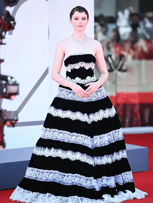 <p>Thomasin McKenzie memilih gaya klasik lewat gaun lace bertingkat hitam-putih rancangan Rodarte. [@themangoblossoms].</p>